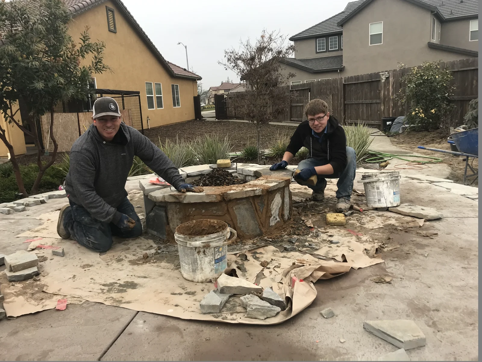 Bryce and his father working together on a stone fire pit.